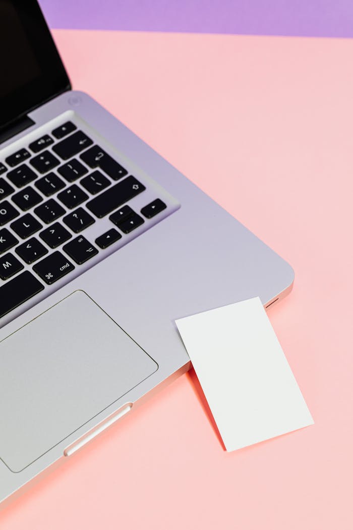 Mastering the First Impression: Your intriguing post title goes here Minimalist photo of a silver laptop with blank paper against pink-purple tones, highlighting modern technology.