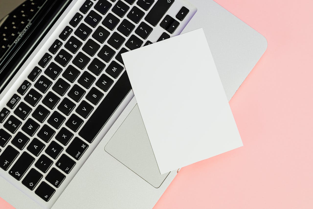 Crafting Captivating Headlines: Your awesome post title goes here A blank card placed on a laptop keyboard with ample copy space on a pastel background.